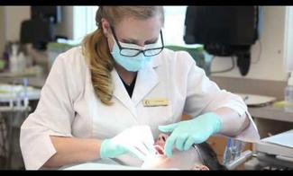 Dental assistant student working on patient